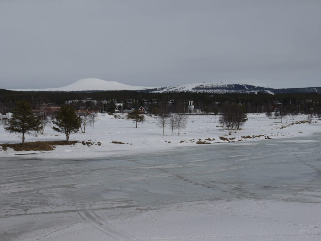 Blick von Südwesten über den See Idresjön (442 m) zum Ort Idre und den Bergen Städjan (1131 m) und Gränjåsvålen (891 m) im Hintergrund am 11.03.2014