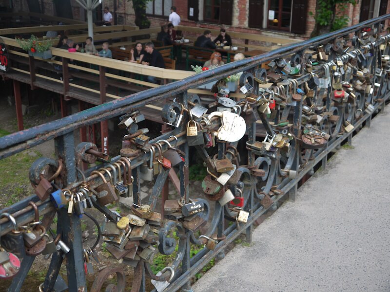 Mit Vorhängreschlössern behangenes Brückengeländer an einer Brücke über den kleinen Fluß Vilnia beim Stadtteil Užupis. (09.07.2017)