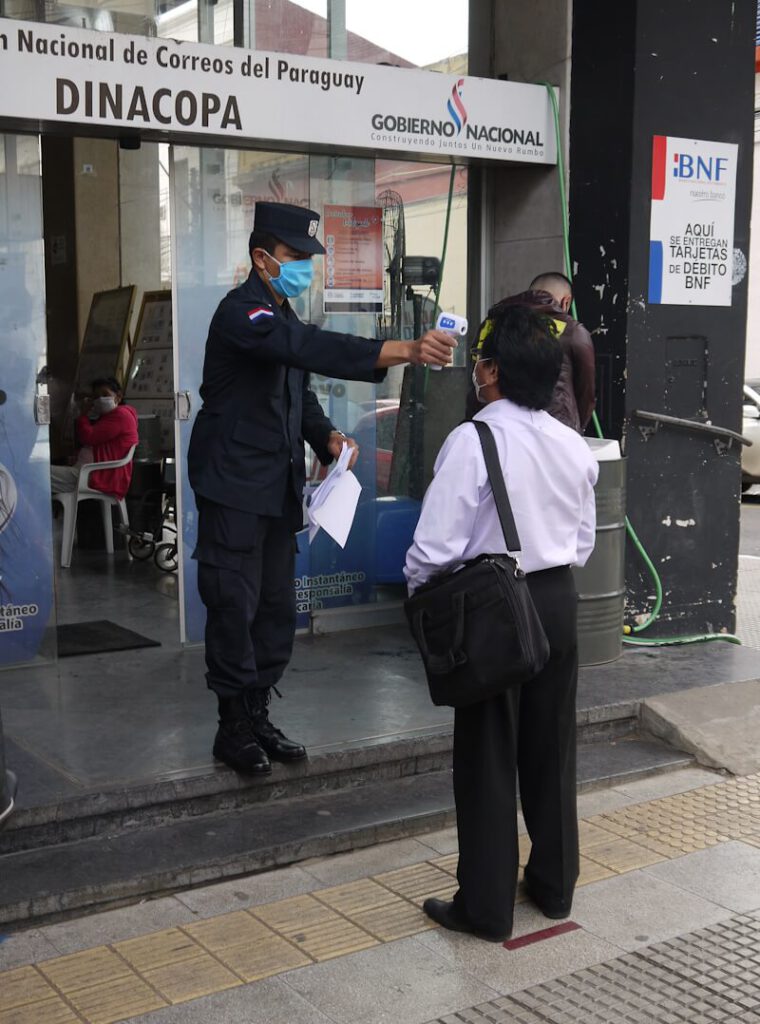 Offizielle Temperaturmessung vor dem Betreten des Hauptpostamtes in der Stadt Asunción in Paraguay während der sogenannten "Corona-Krise" am 20.05.2020.