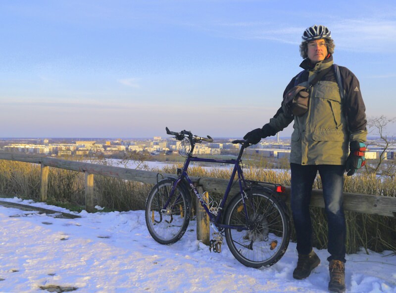 Manfred auf dem Berg "Dörferblick" (86 m) am Mauerradweg im Süden der Metropole Berlin mit Blick auf den Ort Schönefeld am 20.02.2025.