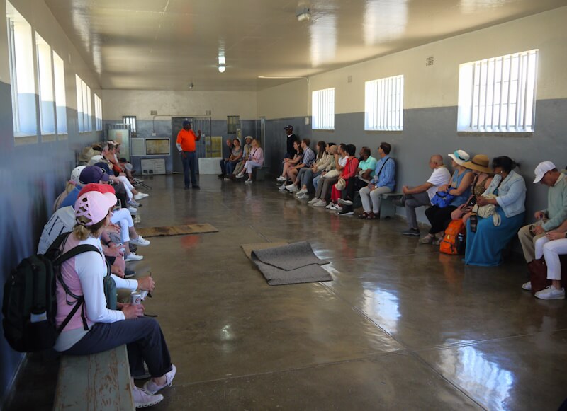 A former inmate of the prison and camp complex on Robben Island recounts the former conditions of imprisonment to visitors on November 3, 2025.
